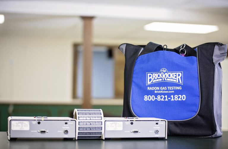 A bag of The BrickKicker next to a measurement tool